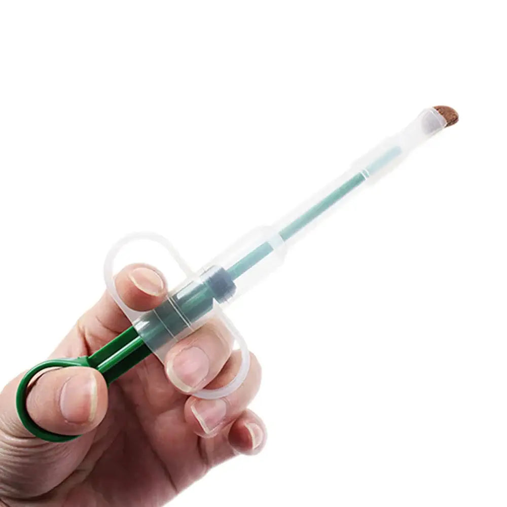 Syringe filled with a pale green liquid being held by a hand.