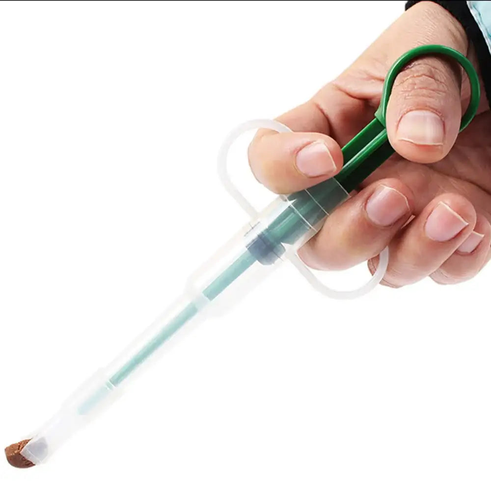 Syringe with green plunger held by a hand.