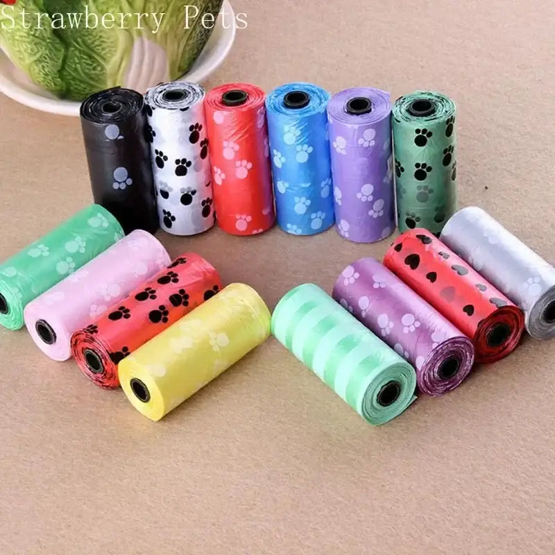 Colorful rolls of plastic dog waste bags with paw print designs.