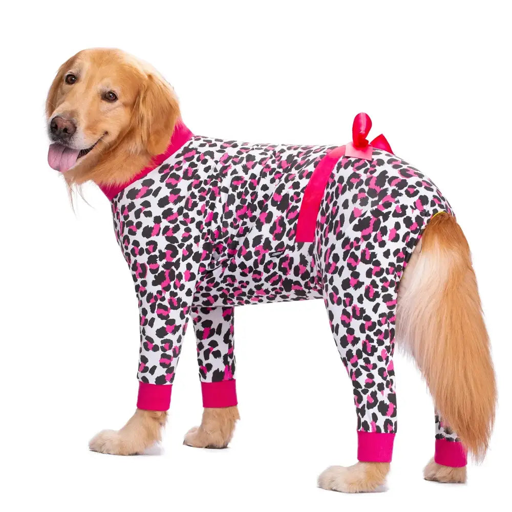 Golden retriever wearing a leopard-print onesie with pink trim.