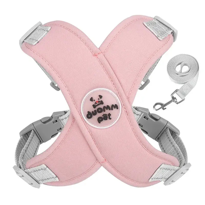 Pink dog harness with adjustable straps and a circular logo patch.