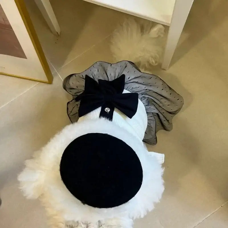 Plush toy resembling a cartoon ghost or spirit with a large black circular spot and bow tie.