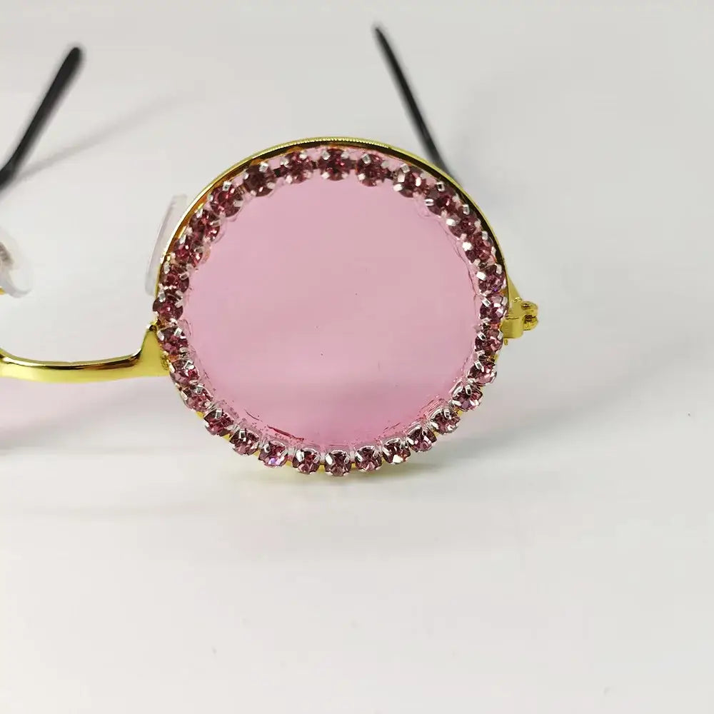 Round pink sunglasses with rhinestone-studded frames.