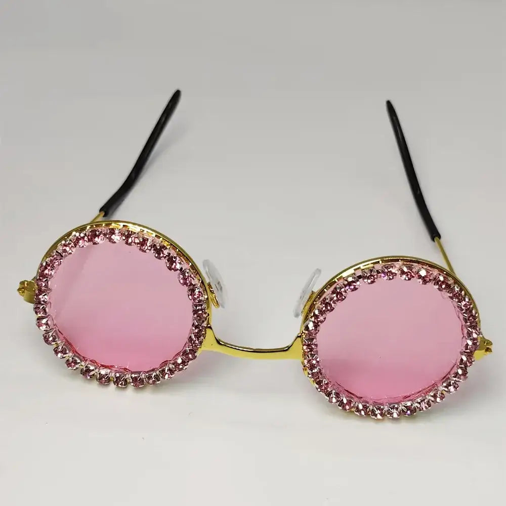 Round sunglasses with pink lenses and rhinestone-encrusted frames.