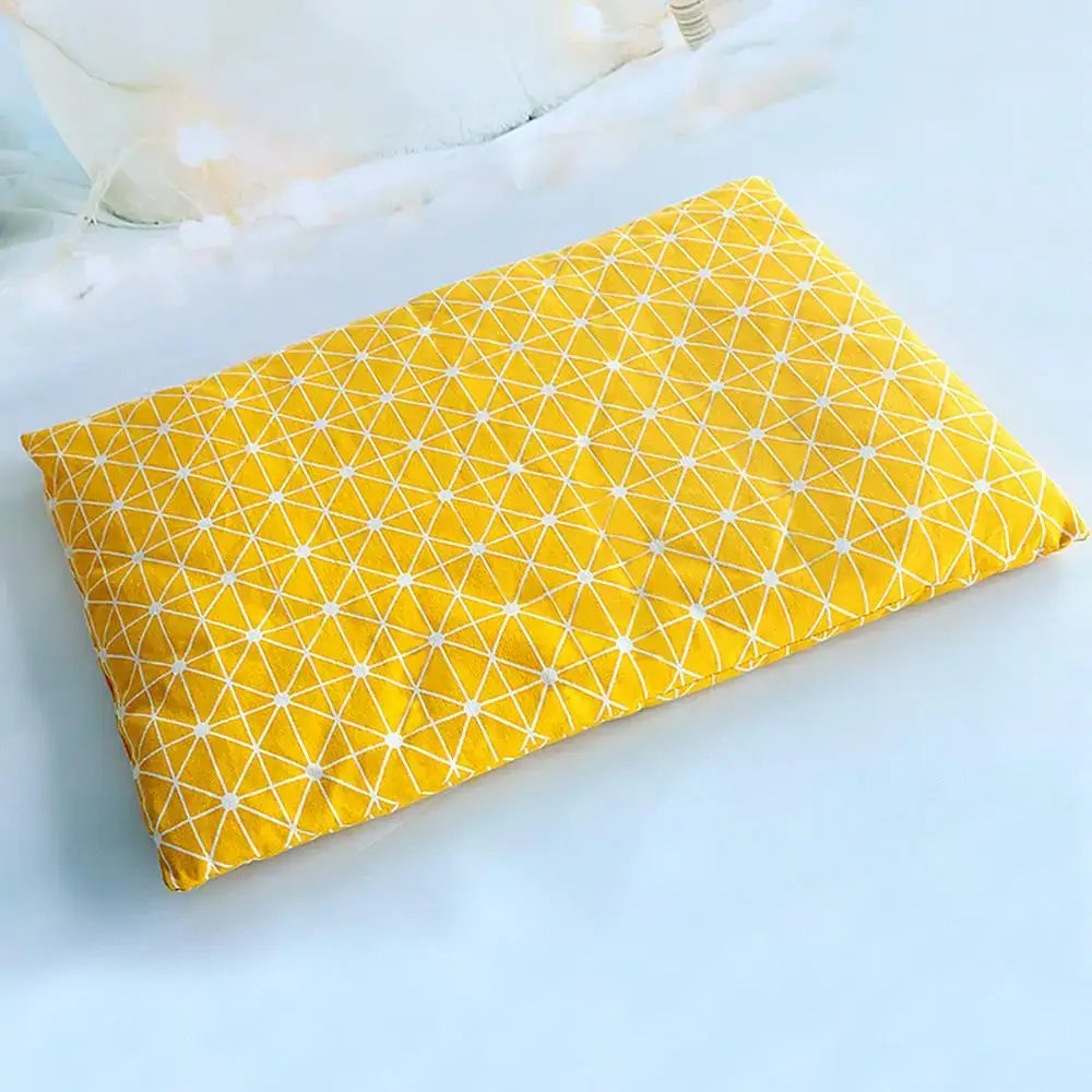 Bright yellow fabric with a white geometric pattern of intersecting lines forming triangles.