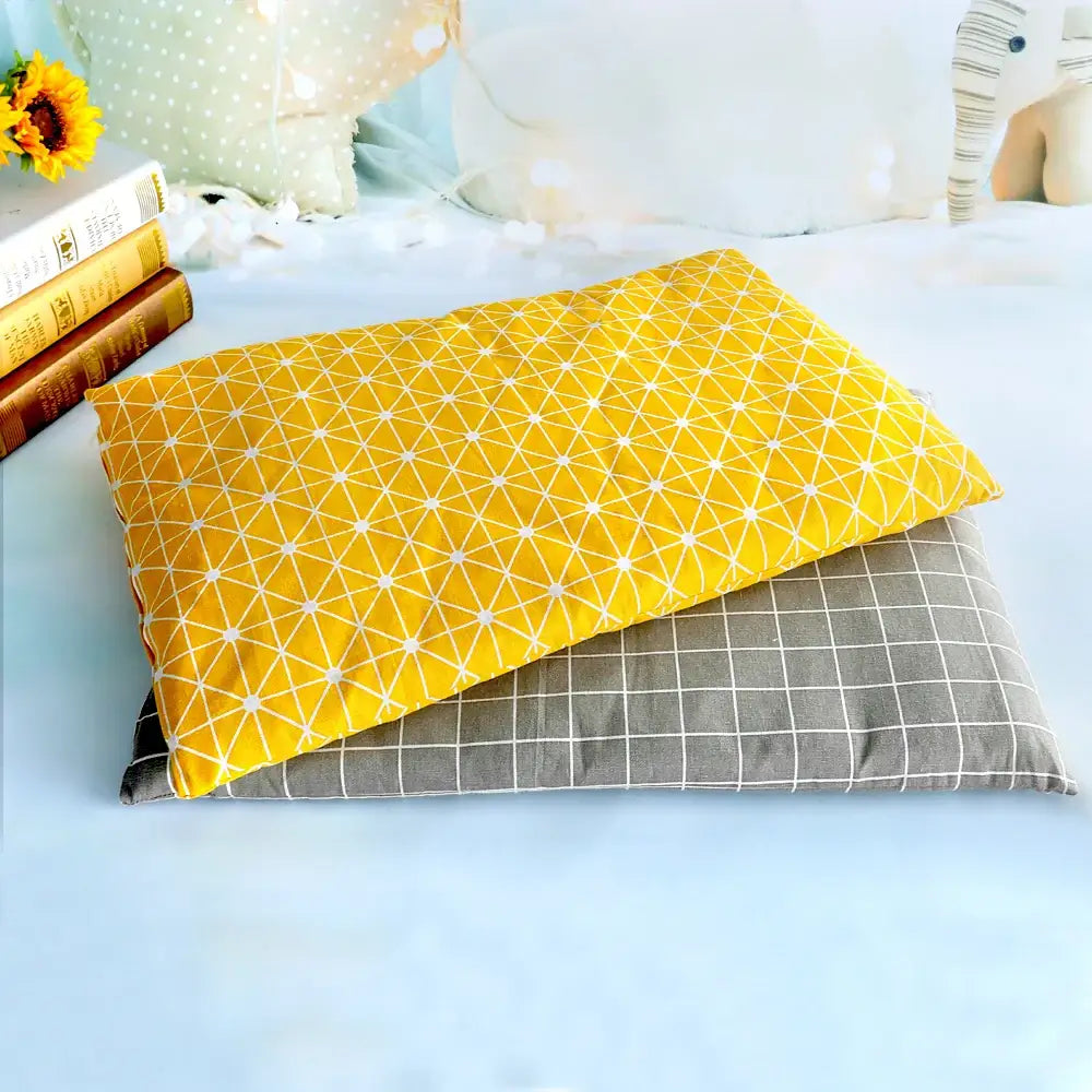 Bright yellow and gray patterned pillows or cushions stacked together.