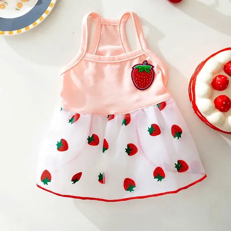 Sleeveless pink and white dress with strawberry print and a strawberry appliqué.