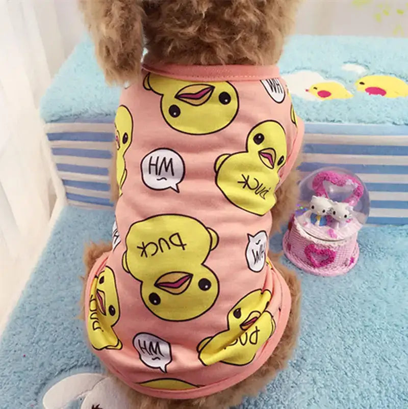 Dog wearing a pink shirt with yellow duck face patterns.