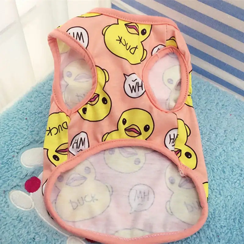 Pink dog vest with yellow duck face pattern and speech bubble designs.