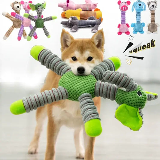 Dog holding a green and gray plush toy in its mouth.