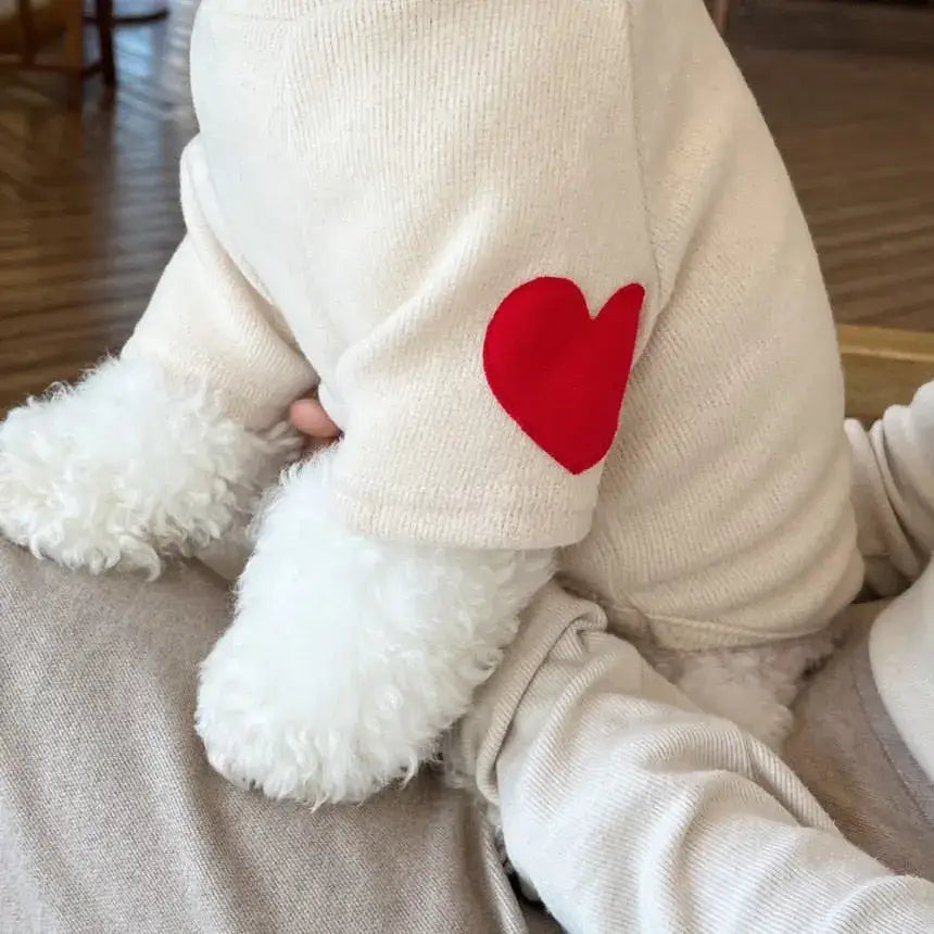 White onesie with a red heart patch on the sleeve.