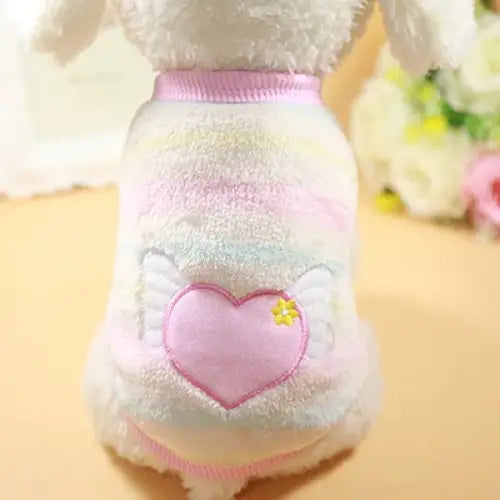 Fluffy white dog sweater with a pink heart design on the back.