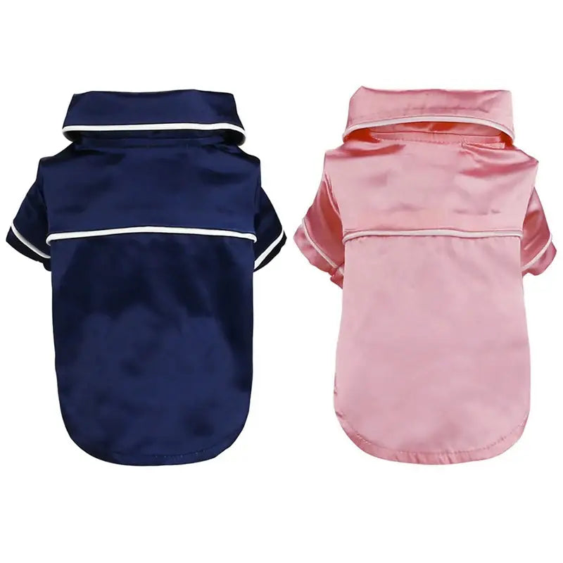 Two dog shirts or pet outfits, one navy blue and one pink.