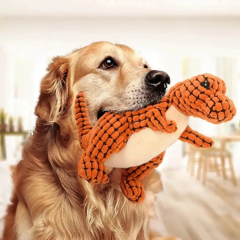 Golden Retriever holding an orange plush dinosaur toy in its mouth.