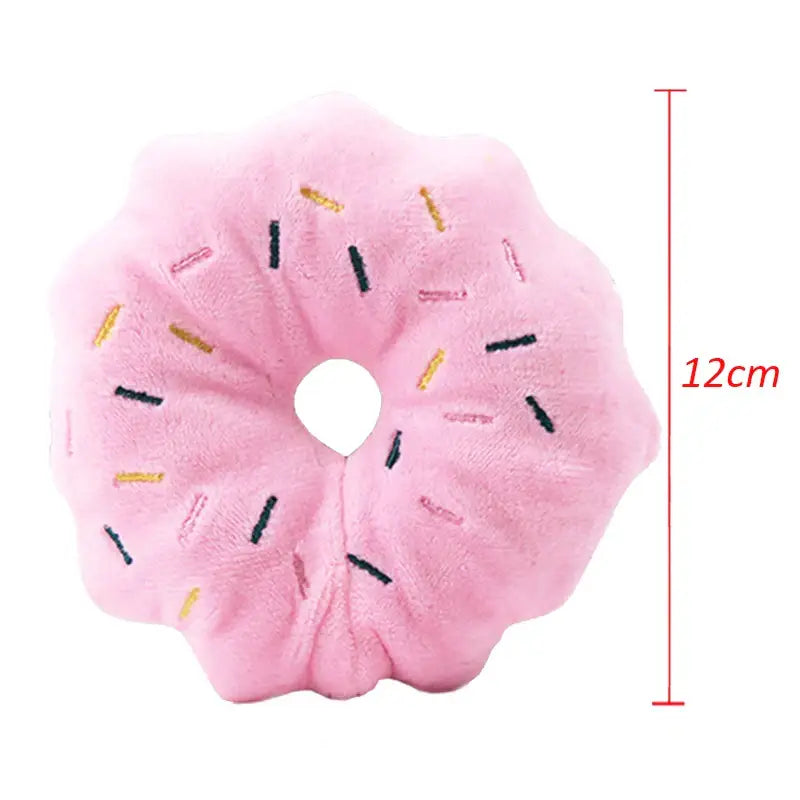 Pink plush donut pillow with colorful sprinkles.