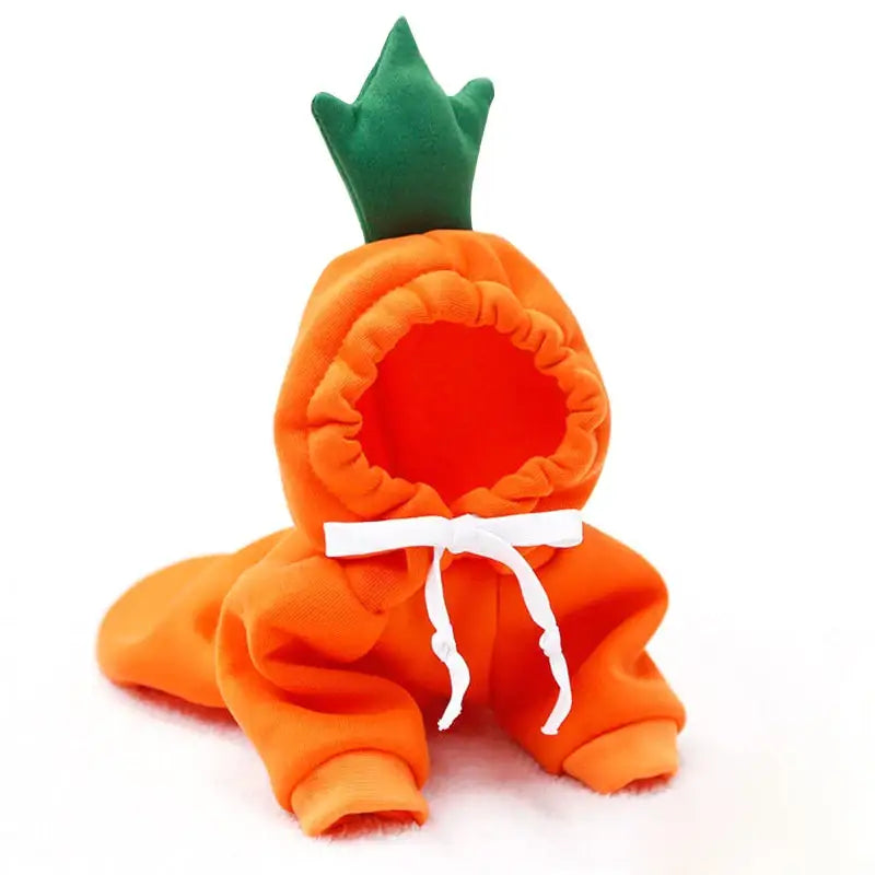 Plush toy shaped like a carrot with a green leafy top and orange body tied with a white ribbon.