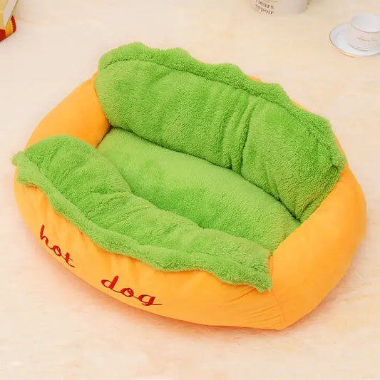 Bright green and orange plush pet bed shaped like a hot dog.