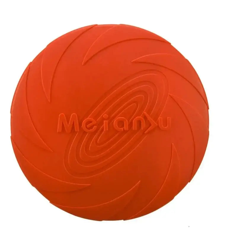 Orange rubber dog toy disc with spiral pattern and ’Merano’ embossed on it.