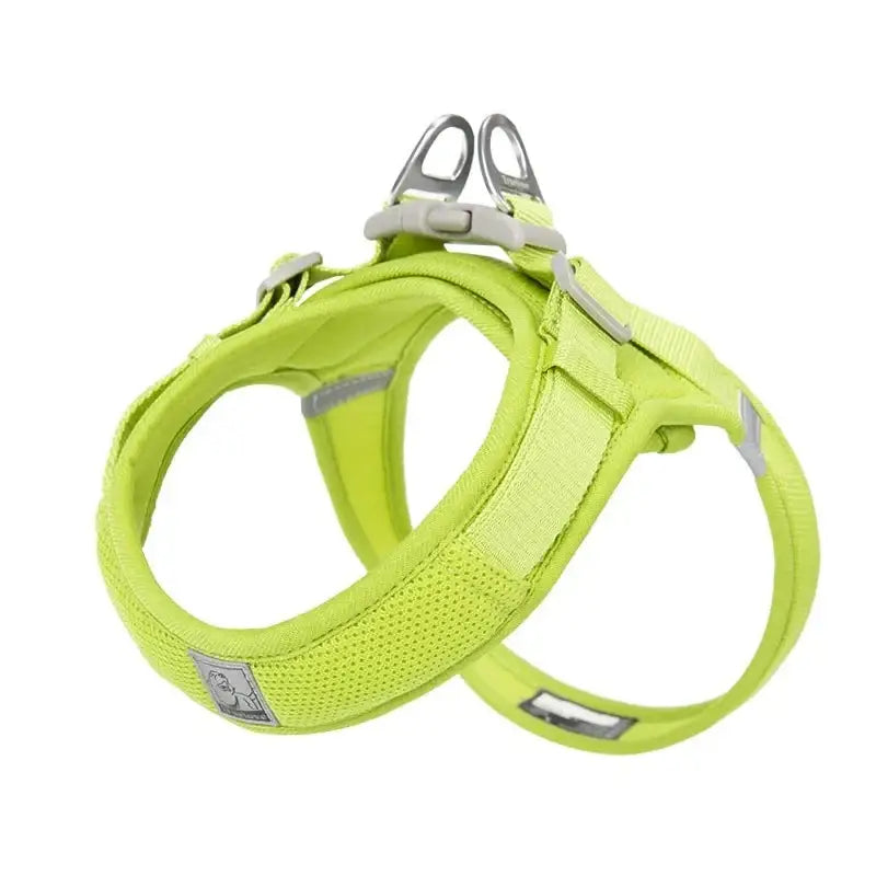 Bright lime green dog harness with reflective strips and metal attachments.