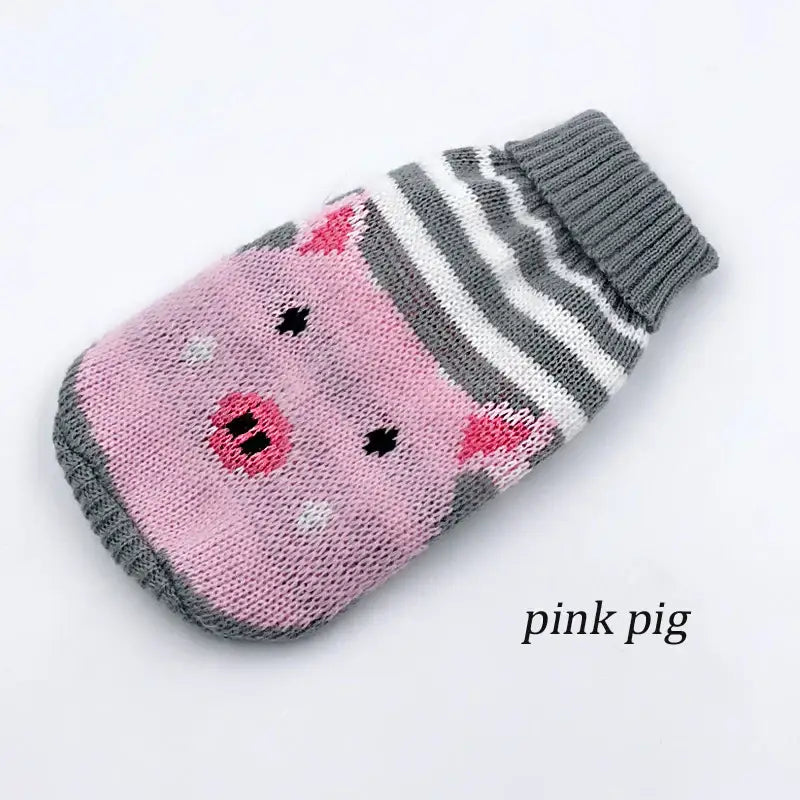 Knitted pink pig-shaped mitten or hand warmer with gray stripes.