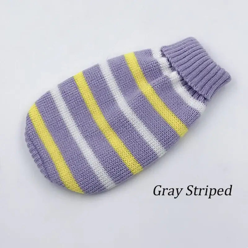 Striped knitted hot water bottle cover in gray, yellow, and white.