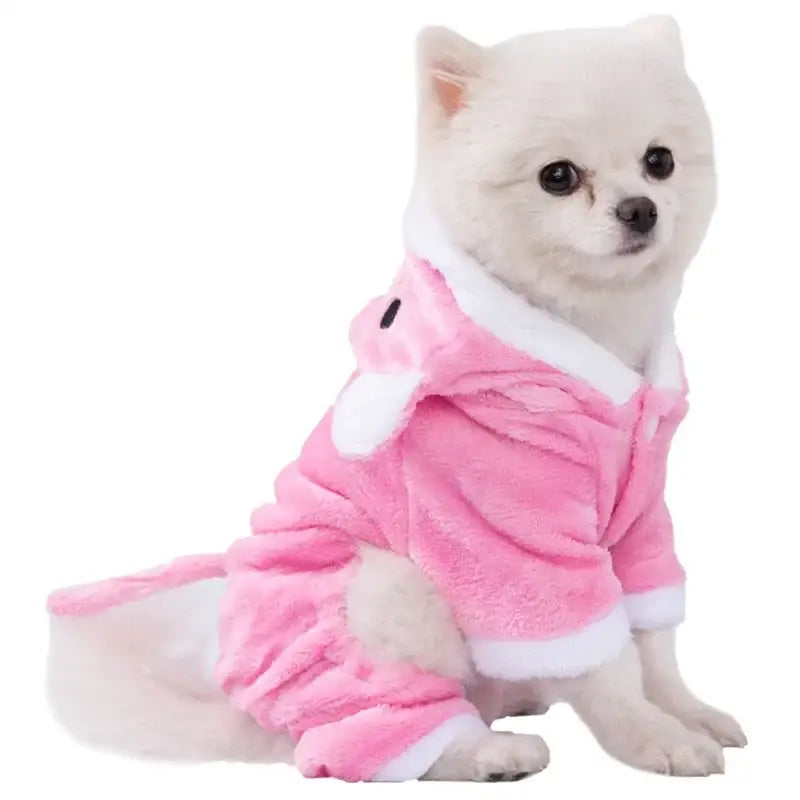 White dog wearing a pink outfit resembling pajamas or a onesie.