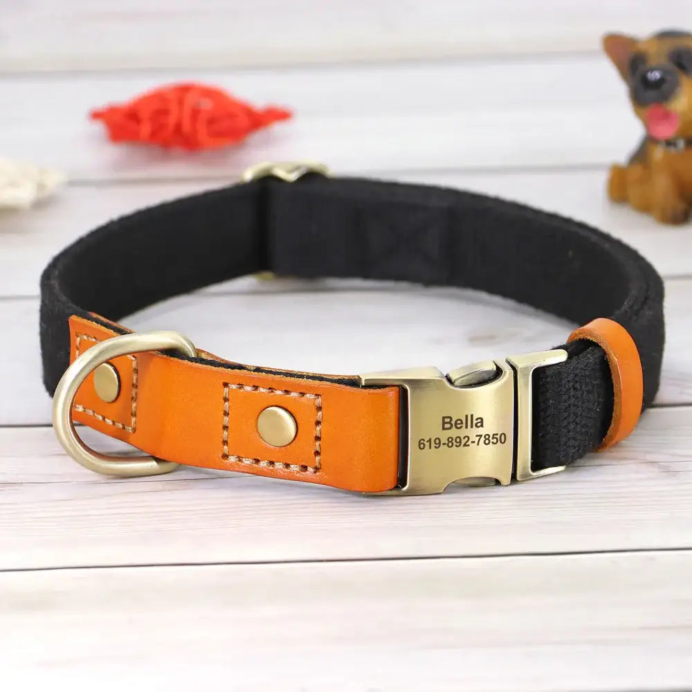 Dog collar with a black fabric band and orange leather accents, featuring a personalized metal tag.