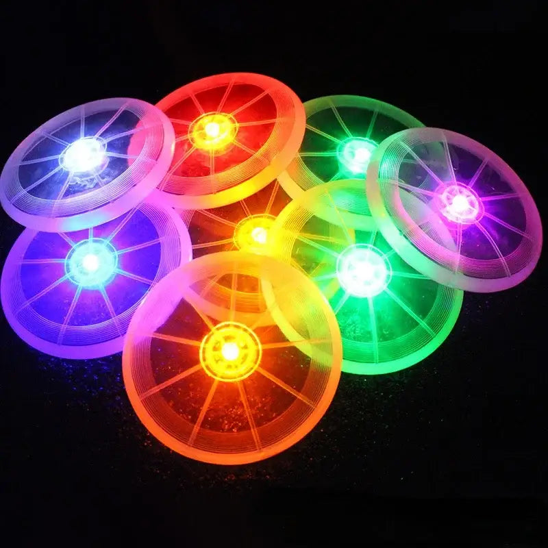 Colorful, illuminated LED frisbees or flying discs glowing in various bright hues.