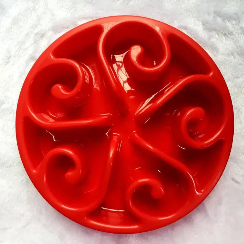 Red circular plastic mold with swirling spiral patterns.