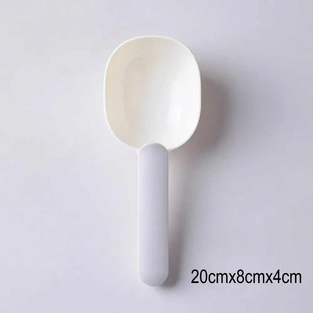 White plastic serving spoon or scoop with a rounded bowl and straight handle.