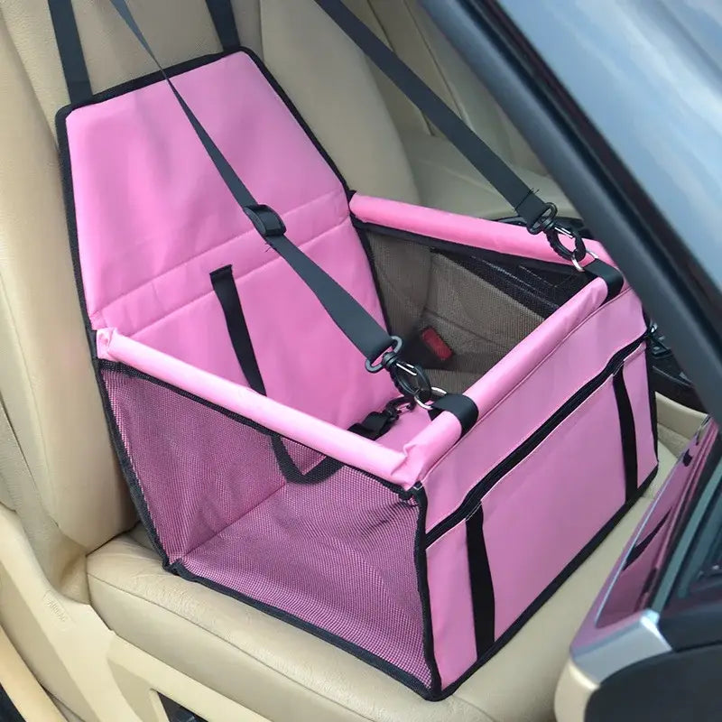 Pink pet car seat with mesh sides and safety straps.