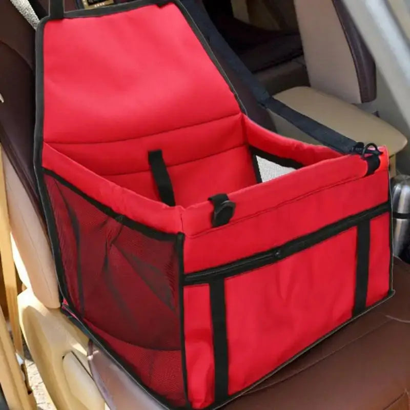 Red pet car seat carrier with safety straps and mesh sides.