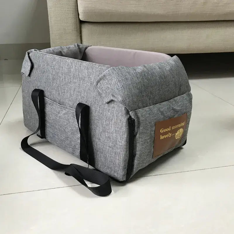 Gray fabric pet carrier with handles and a shoulder strap.