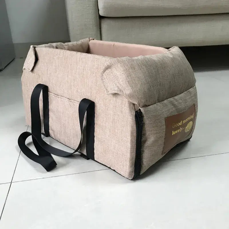 Pet carrier bag made of beige fabric with black straps.