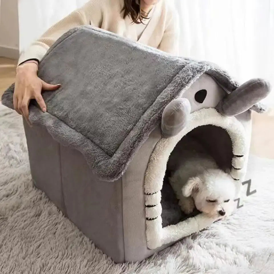 Plush gray dog house with a sleeping puppy inside.