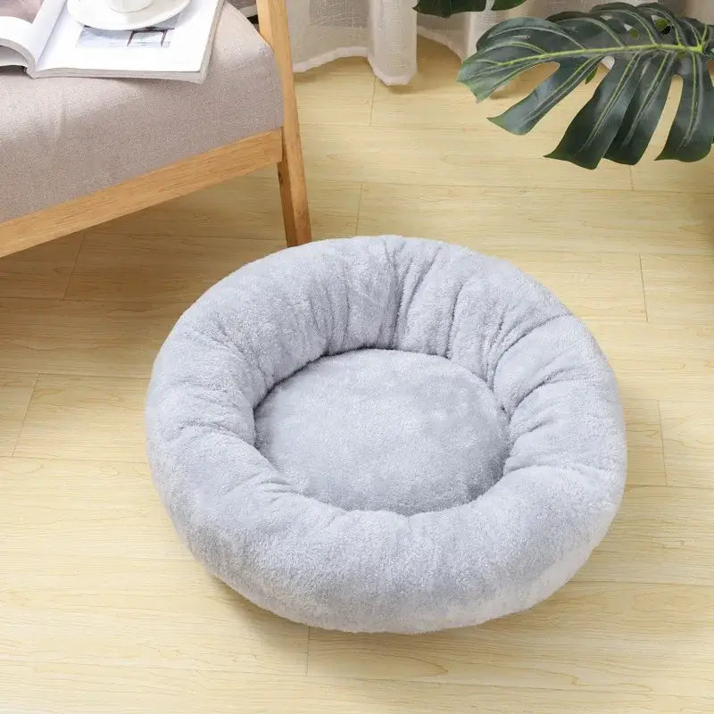 Circular gray plush pet bed with raised edges.