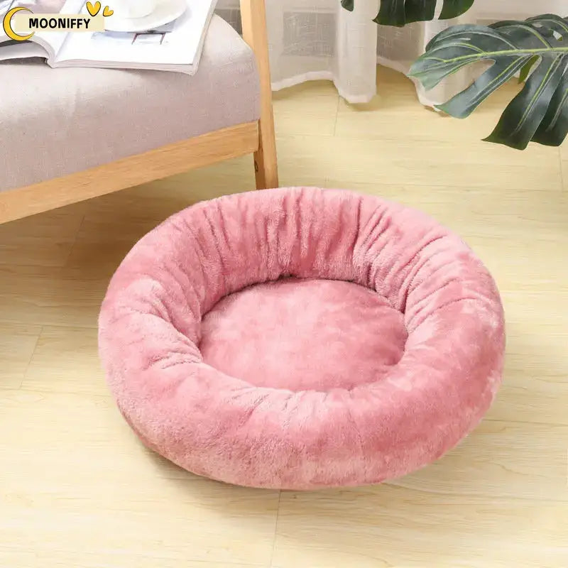 Pink, round, plush pet bed with raised edges.