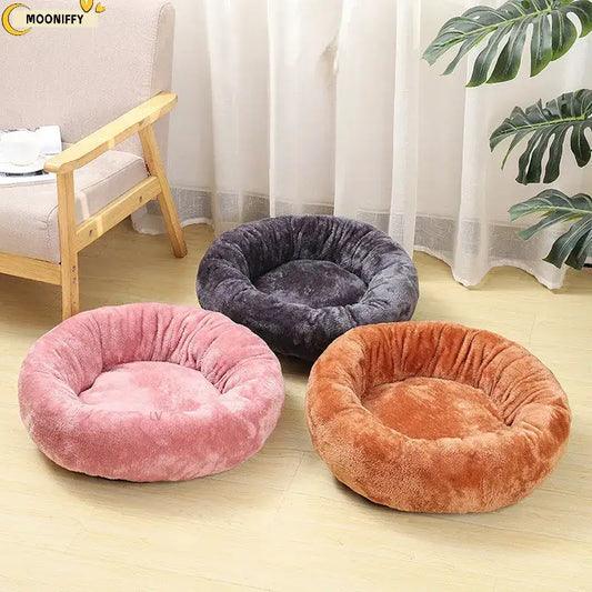 Plush, round pet beds in pink, gray, and orange colors.