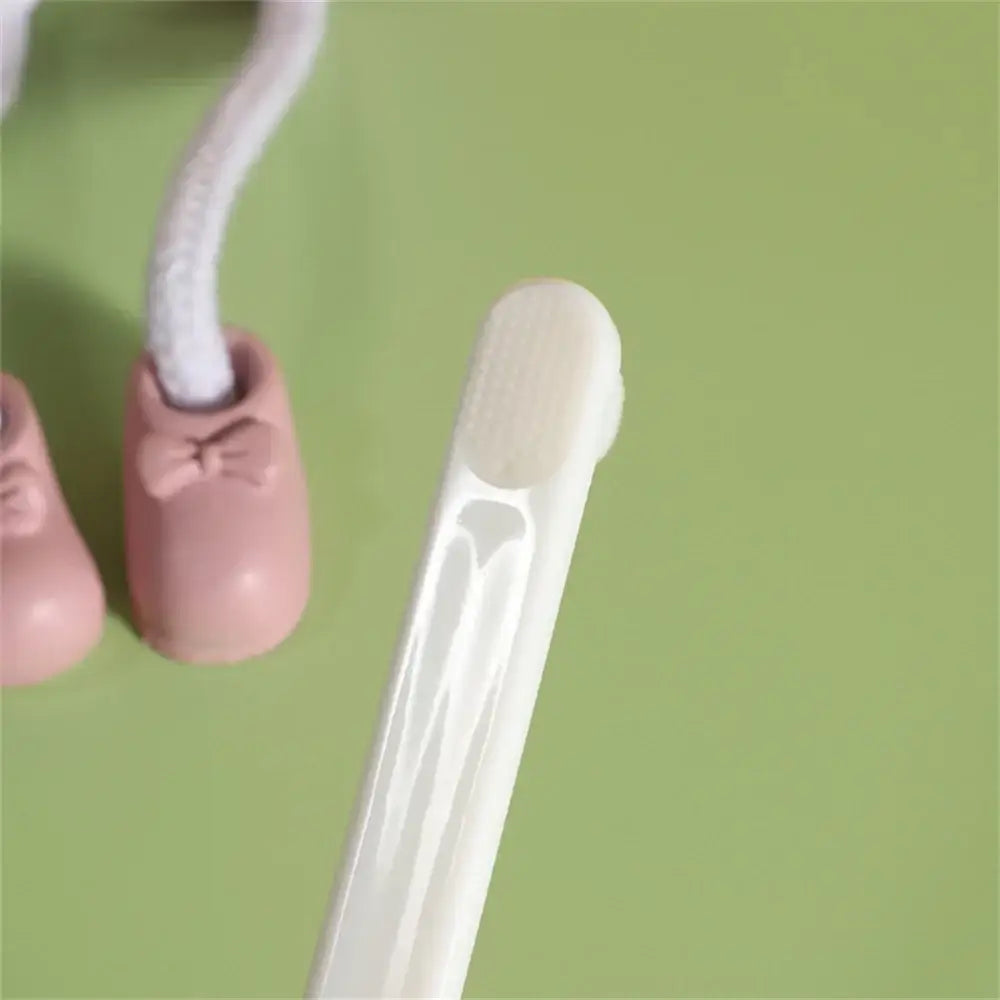 Tampon with applicator next to pink ballet shoes.