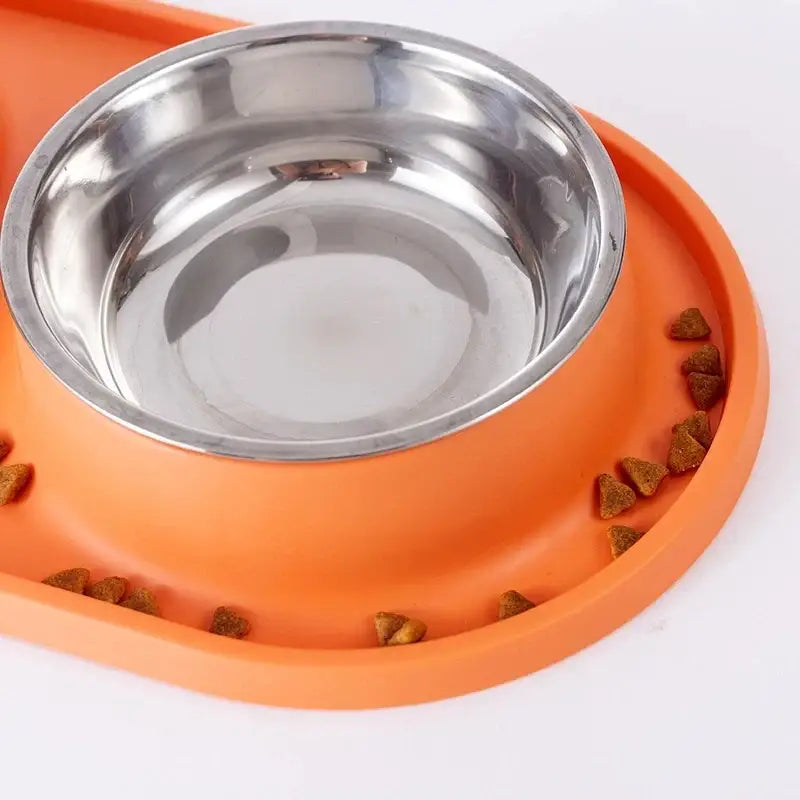 Orange pet food bowl with a stainless steel insert and slow-feeding ridges.