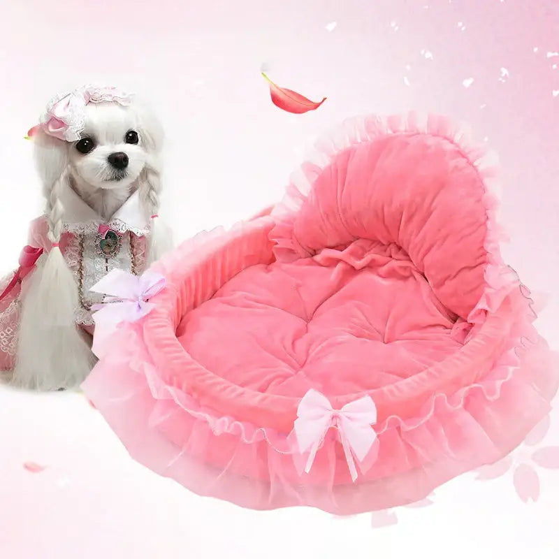 Pink, frilly, heart-shaped pet bed with a decorative bow.