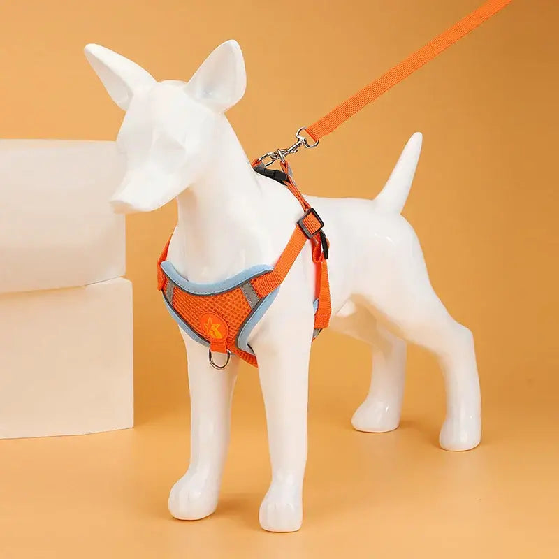 White dog mannequin wearing an orange harness and leash.