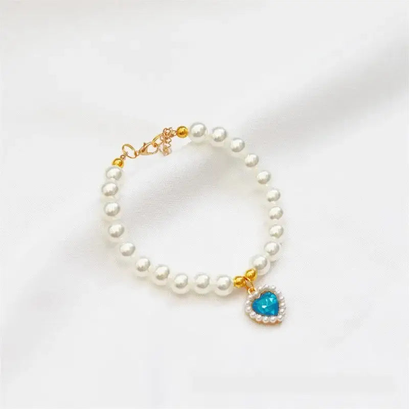 Pearl bracelet with a turquoise heart-shaped charm.