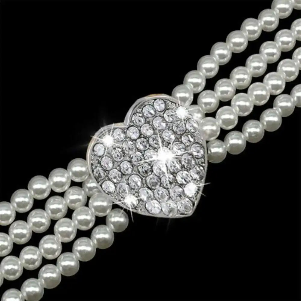 Heart-shaped diamond pendant on multiple strands of pearls.