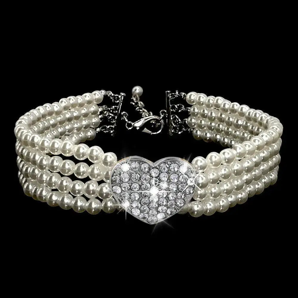 Pearl bracelet with a diamond-encrusted heart centerpiece.