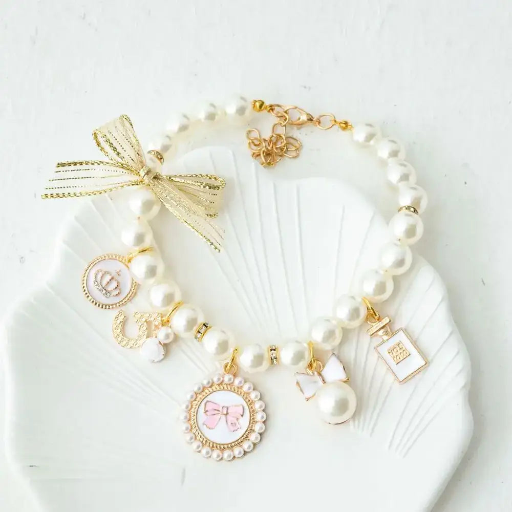 Pearl charm bracelet with gold accents and decorative pendants.