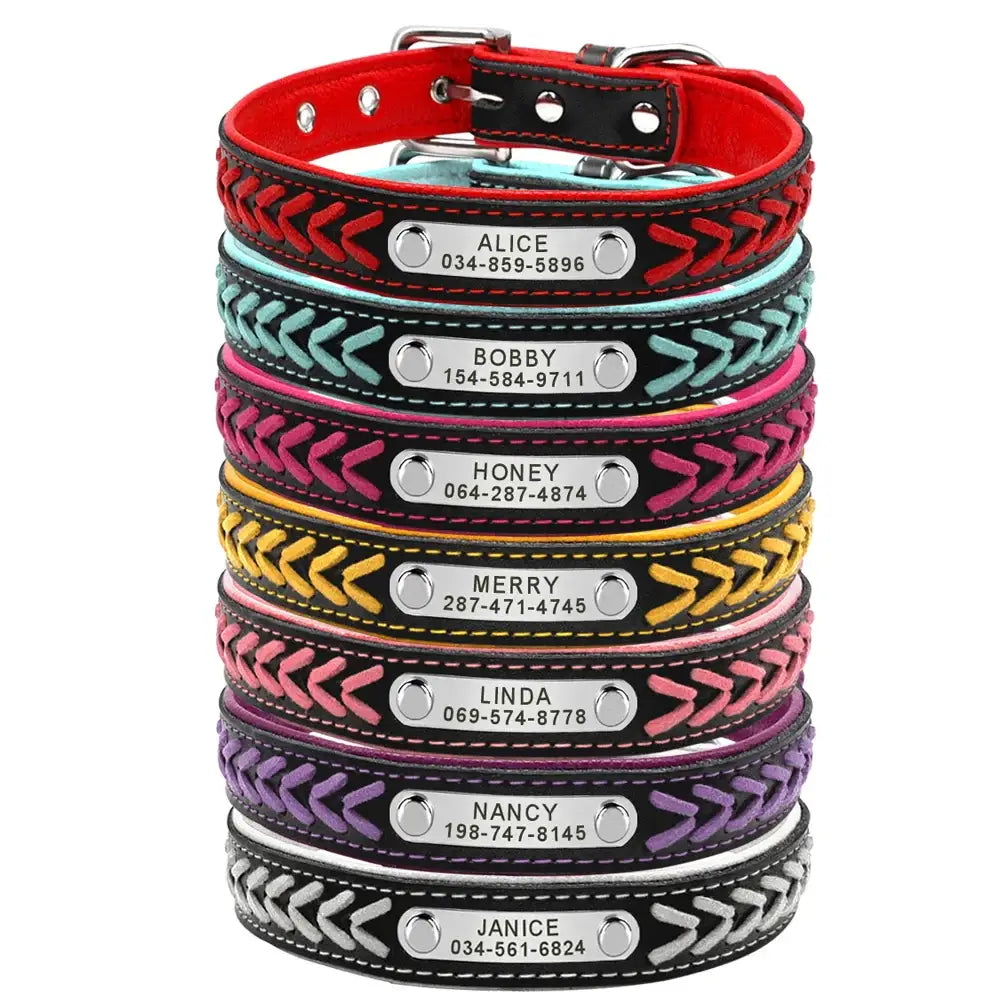 Stack of colorful leather dog collars with personalized name tags and phone numbers.