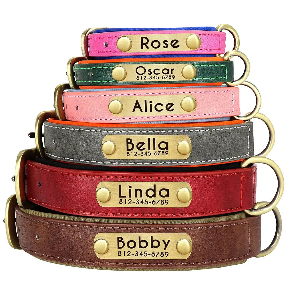 Stack of personalized leather dog collars in various colors with engraved name plates.