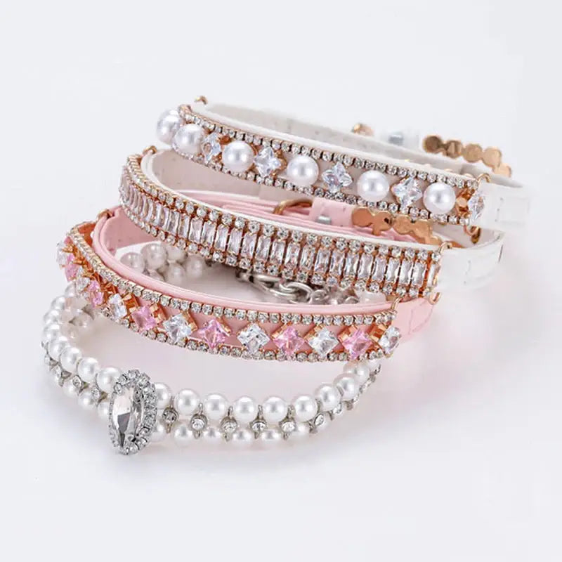 Stack of decorative bracelets featuring pearls, crystals, and metallic accents in pink and silver tones.