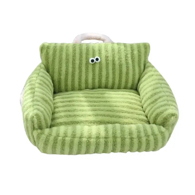 Green plush armchair with cartoon eyes and a handle on top.